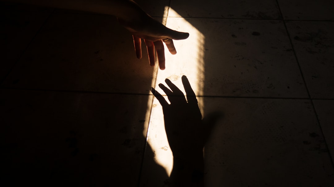Close-up of a human hand gently touching a series of futuristic, glowing digital lines, symbolizing the connection between...