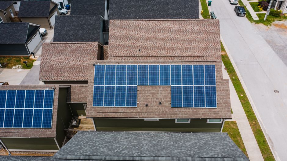 Modern home in Atlanta featuring solar panels on the roof under a bright, sunny sky, representing a smart investment in re...